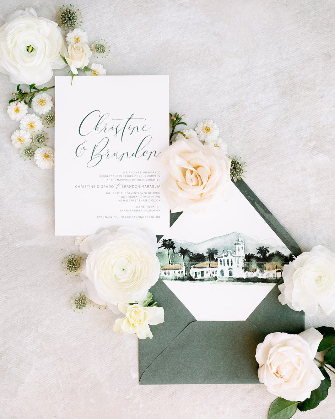 Wedding invitation card with envelope and floral decorations on a light background